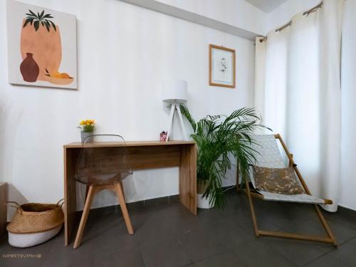 un bureau et une chaise dans une chambre avec une plante dans l'établissement Le Gustave - Climatisation et cœur de ville, à Montpellier