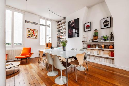 une salle à manger blanche avec une table et des chaises blanches dans l'établissement Veeve - Haut Marais Glam, à Paris