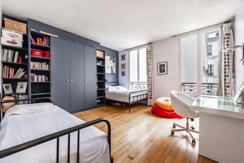 une chambre avec un lit et un bureau dans l'établissement Veeve - Haut Marais Glam, à Paris