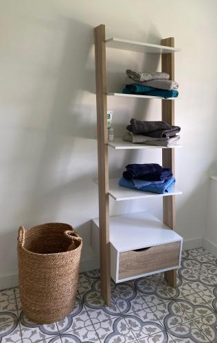 a shelf with towels and a basket in a room at Gite de Beaufournier in Avremesnil