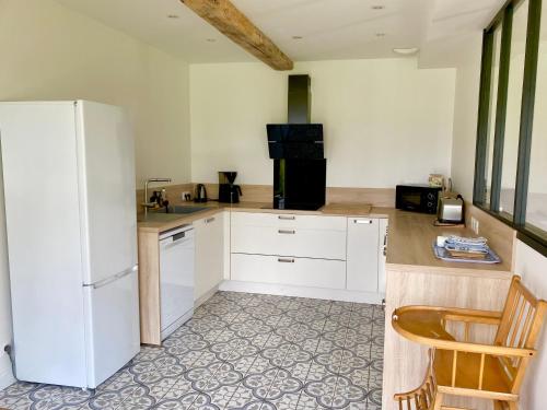 a kitchen with white cabinets and a white refrigerator at Gite de Beaufournier in Avremesnil
