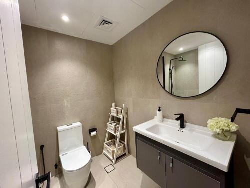a bathroom with a white toilet and a mirror at Luxury Modern Studio I Discovery Gardens in Dubai