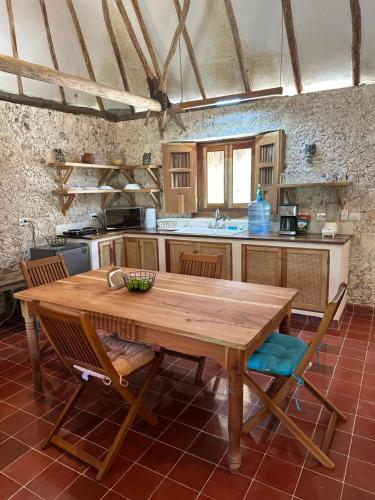 uma grande cozinha com uma mesa de madeira e cadeiras em Hacienda Guesthouse with Private Cenote em Espita
