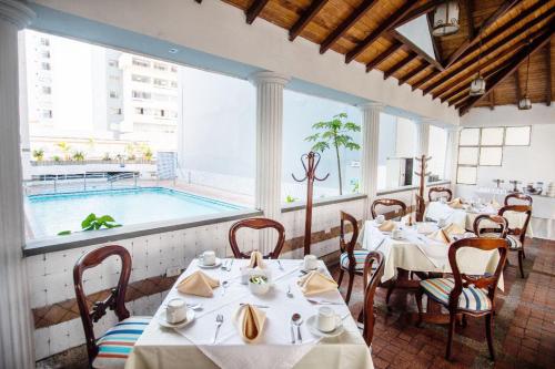 une salle à manger avec des tables et une piscine dans l'établissement Hotel Guane, à Bucaramanga