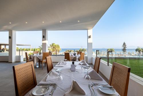 a dining room with a table and a view of the ocean at Atlantica Mikri Poli Kos in Kardamaina