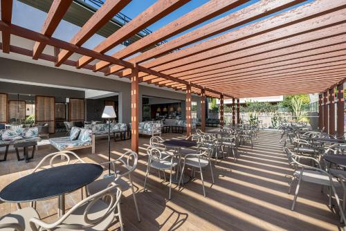 a patio with tables and chairs and tables and tablesktop at Atlantica Mikri Poli Kos in Kardamaina