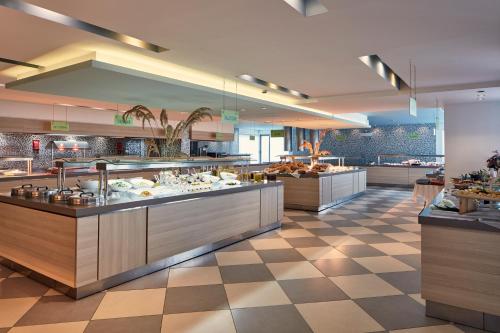 a restaurant with a buffet line with food on display at Atlantica Mikri Poli Kos in Kardamaina