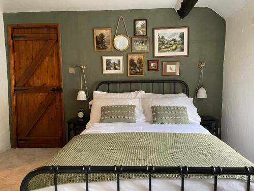 a bedroom with a large bed with a green wall at Lilywood Cottage - 2BR Central Bicester in Bicester