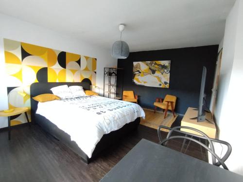 a bedroom with a bed and a table and chairs at La Citronnade in Floreffe
