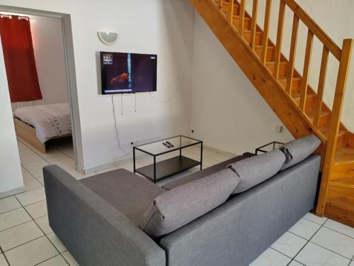 - un canapé dans le salon avec un escalier dans l'établissement Spacieuse et confortable maison avec garage, à Anzin