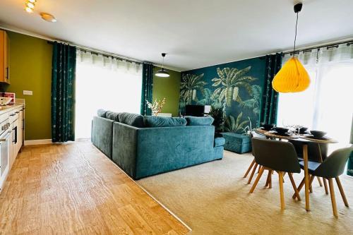 a living room with a blue couch and a table at Cosy apartment at the marina in Portishead