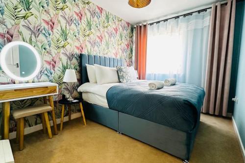 a bedroom with a bed and a desk with a mirror at Cosy apartment at the marina in Portishead