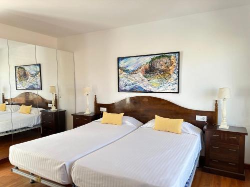 ロザスにあるAgi Riu Segre Villaのベッドルーム1室(ベッド2台付)が備わります。壁には絵画が2点飾られています。