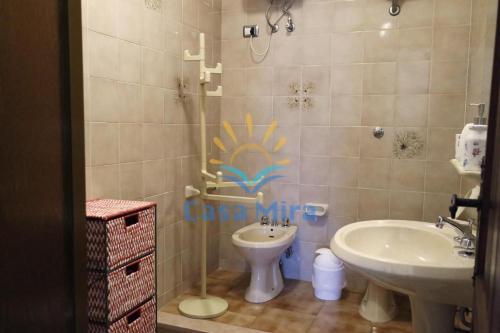 bagno con lavandino e servizi igienici di Mira Holiday Apartment Chia a Chia