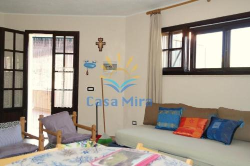 salon z kanapą i krzyżem na ścianie w obiekcie Mira Holiday Apartment Chia w mieście Chia