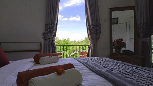 a bedroom with a bed with towels and a balcony at The Royal Terrace Holiday Bungalow in Nuwara Eliya