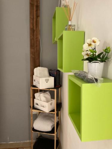 a room with green shelves with towels and flowers at Privilge Gzira in Il-Gżira