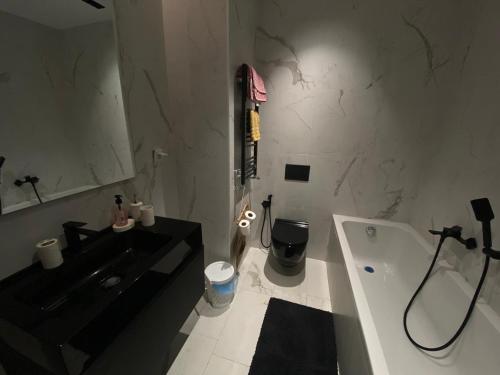 a bathroom with a black sink and a bath tub at Appartement Californien in Sidi Daoud