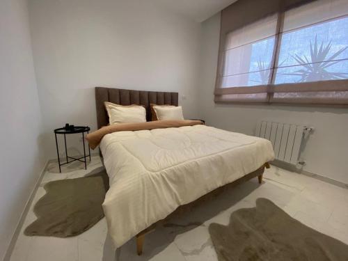 a bedroom with a large bed with a window at Appartement Californien in Sidi Daoud