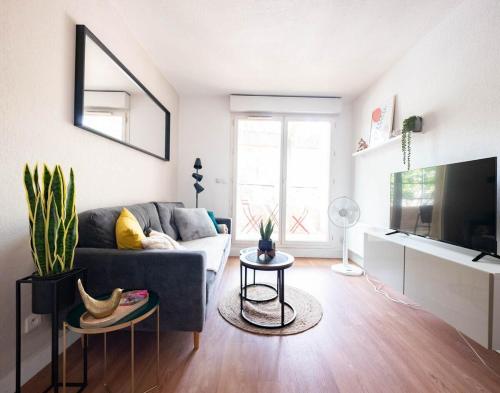 un salon avec un canapé et une télévision dans l'établissement Le Richter - terrasse à Port Marianne, à Montpellier