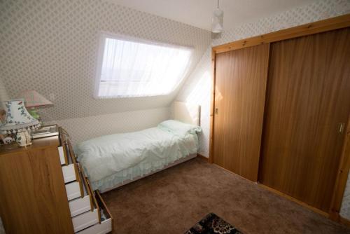 ein kleines Schlafzimmer mit einem Bett und einem Fenster in der Unterkunft Come along and enjoy the beautiful Moray Coast in Buckie