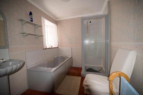 ein Badezimmer mit einer Dusche, einer Badewanne und einem Waschbecken in der Unterkunft Come along and enjoy the beautiful Moray Coast in Buckie