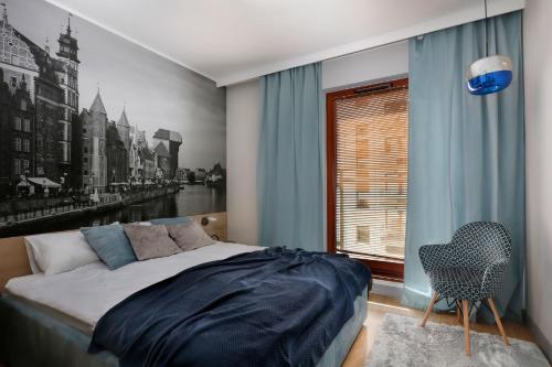1 dormitorio con cama, ventana y silla en City Center - Riverside by Apartmore en Gdansk