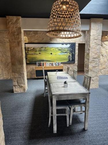 ein Esszimmer mit Tisch und Stühlen und einem Kronleuchter in der Unterkunft Pestana Gramacho Residences in Ferragudo