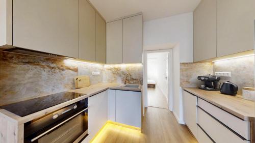 a kitchen with white cabinets and a counter top at Ambient apartment in Žilina