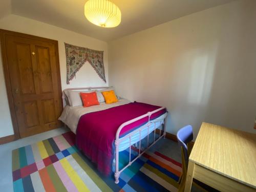 a small bedroom with a bed and a table at Rivendell in Diss