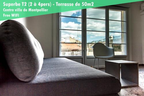 a bedroom with a bed and a chair and windows at L'amoureux - terrasse et climatisation coeur de ville in Montpellier