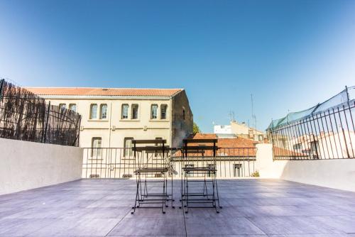 un groupe de chaises assises sur le toit d'un bâtiment dans l'établissement L'amoureux - terrasse et climatisation coeur de ville, à Montpellier