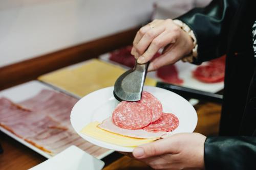 a person cutting a piece of meat on a plate at Hostal Concepcion in Concepción