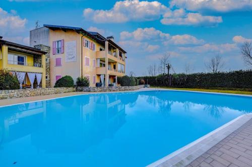 a large swimming pool in front of a building at Maison Martina in Lonato del Garda