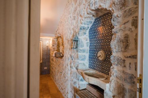 La salle de bains est pourvue d'un mur en pierre et d'un lavabo. dans l'établissement Villa la Campanella by Elite Villas, à Ravello