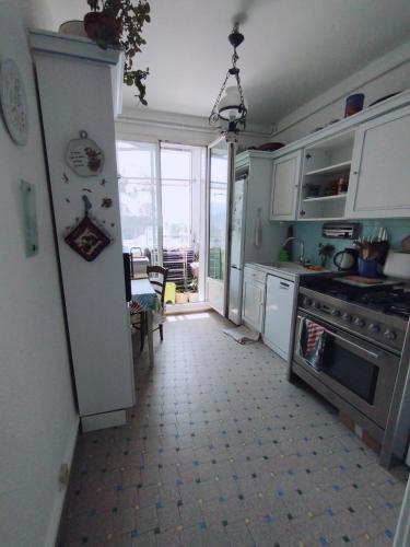 Il comprend une cuisine équipée d'un réfrigérateur blanc et d'une table. dans l'établissement chambre rouge, à Grenoble