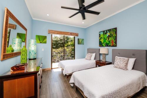 a bedroom with two beds and a ceiling fan at Villa Hibiscus in Tamarindo