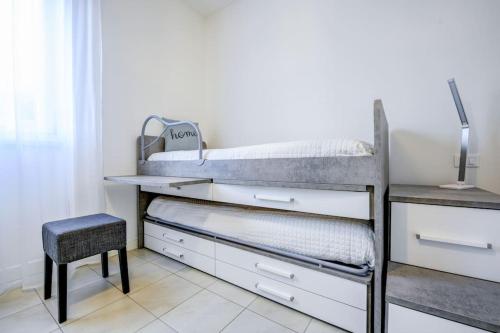 a bedroom with a bunk bed with a chair and a stool at Maison Martina in Lonato del Garda
