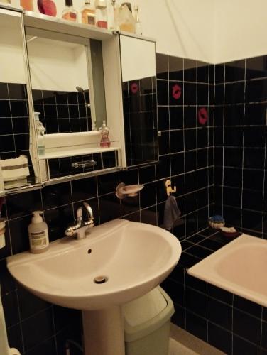 een badkamer met een wastafel en een spiegel bij chambre rouge in Grenoble