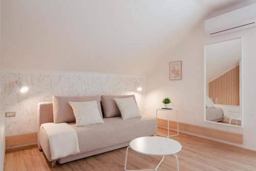 リュブリャナにあるLuxury 2 bedroom NEW apartment with private parkingのソファとテーブルのある白いリビングルーム