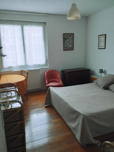 chambre rouge في غرونوبل: غرفة نوم بسرير وطاولة وكرسي