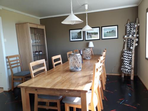 a dining room with a wooden table and chairs at Feriehus ved Barentshavet - Holiday home by the Barents Sea in Ytre Kiberg