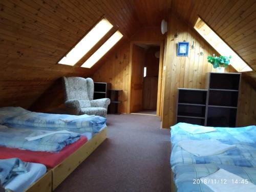a room with two beds and a chair in a cabin at chata Alice in Rokytnice nad Jizerou