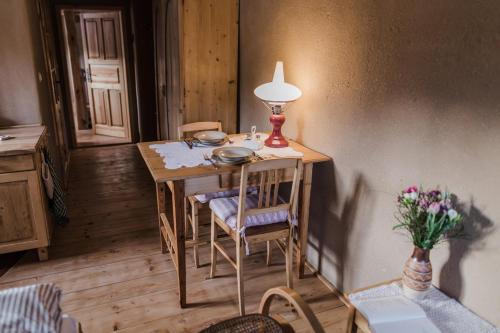 una mesa con una lámpara y sillas en una habitación en Přírodní Wellness penzion Krásná Samota, en Děčín