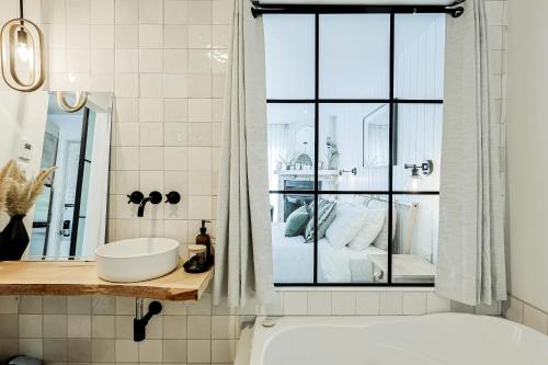 a bathroom with a tub and a sink and a shower at Les Lofts du Lac des Sables by Gestion ELITE in Sainte-Agathe-des-Monts