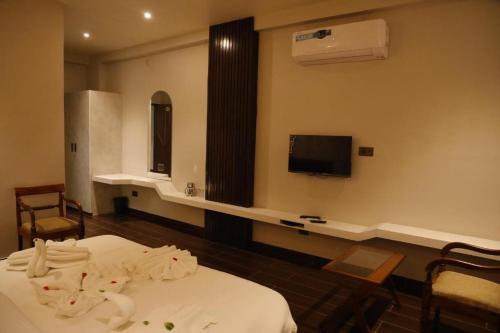 a hospital room with a bed and a tv at Hotel 777, Pushkar By Shivaneel Hospitality in Pushkar