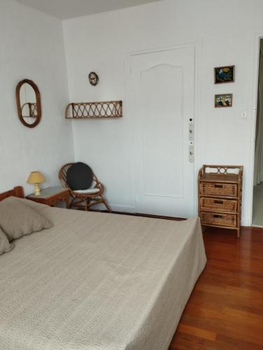 a bedroom with a bed and a table and a chair at chambre rouge in Grenoble