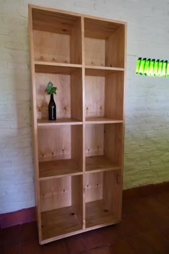 a wooden book shelf against a wall at Hyena Hill Lodge in Sanga