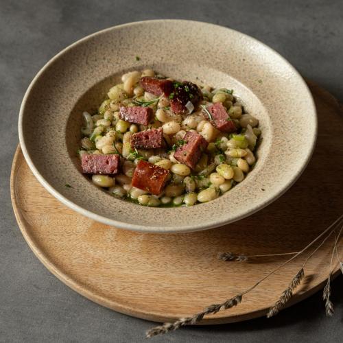 a bowl of food with meat and beans on a plate at Unedo All Seasons Boutique Hotel in Palaios Panteleimon