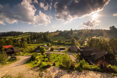 an aerial view of a house in the hills with the sun setting at Casa Poveste Pensiunea-Muzeu in Câmpulung Moldovenesc